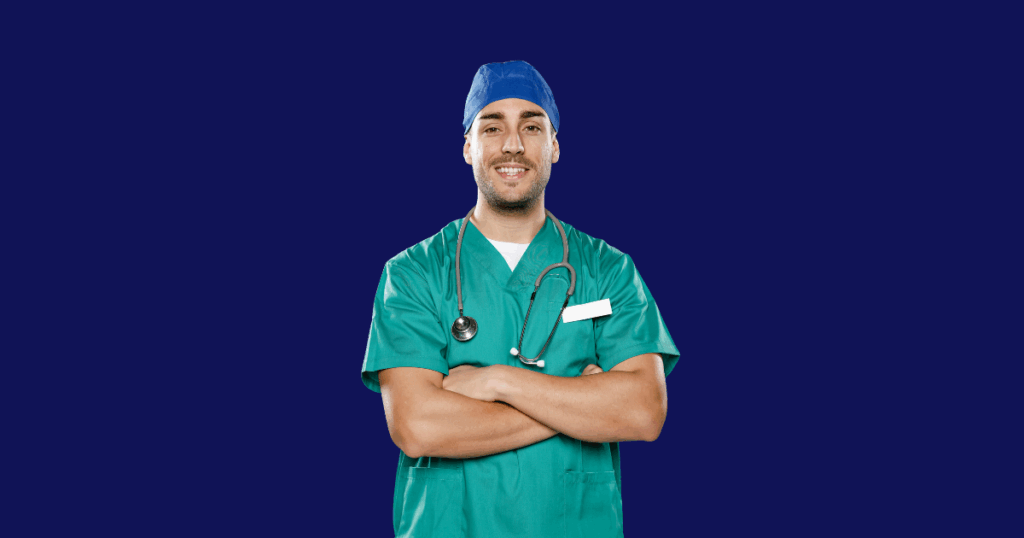 Médico sorridente com barba, vestindo uma touca azul e uniforme cirúrgico verde, tem os braços cruzados. Um estetoscópio está pendurado em seu pescoço. O fundo da imagem é azul escuro.
