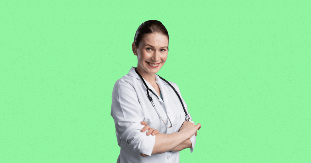 Médica sorridente com jaleco branco e estetoscópio no pescoço, de braços cruzados, sobre fundo verde-claro.
