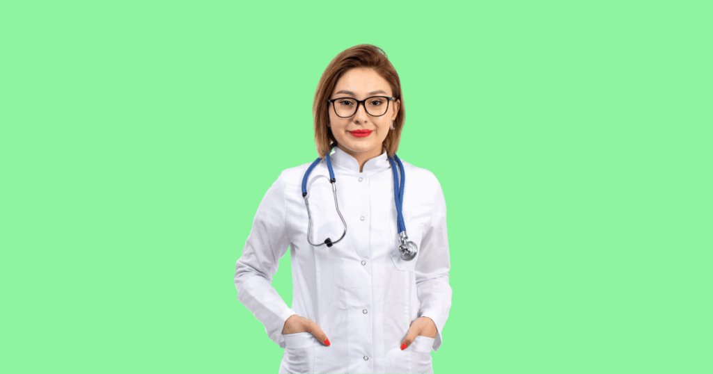 Uma médica de cabelo castanho, óculos, jaleco branco e estetoscópio, com as mãos nos bolsos e um sorriso.