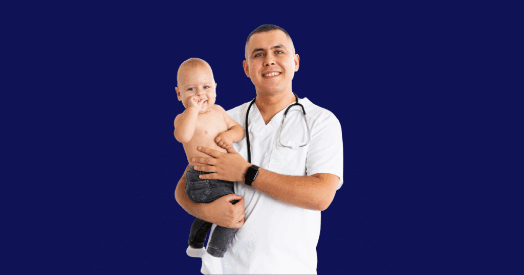Médico sorridente com estetoscópio no pescoço segurando um bebê loiro de calça jeans sem camisa, ambos olhando para a câmera, com fundo azul escuro sólido.