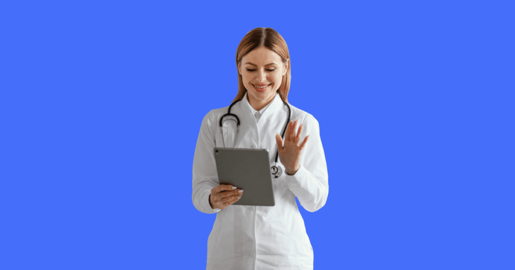 Médica com jaleco branco e estetoscópio acenando com uma mão e segurando um tablet com a outra, em frente a um fundo azul.