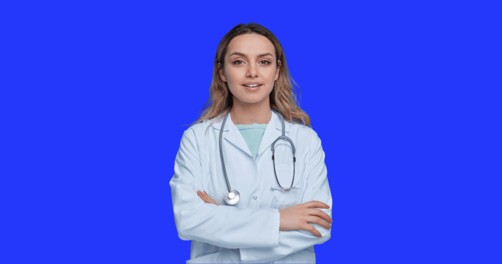 Médica jovem de jaleco branco com estetoscópio no pescoço e braços cruzados, sobre fundo azul sólido.