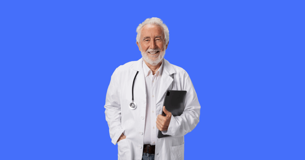 Médico idoso sorridente com jaleco, estetoscópio e tablet, fundo azul.