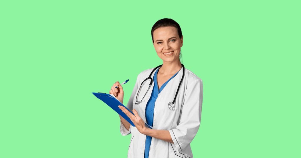 Médica sorridente com cabelos presos, vestindo jaleco branco e roupa azul, segurando uma prancheta azul com uma caneta na mão, diante de um fundo verde-claro.