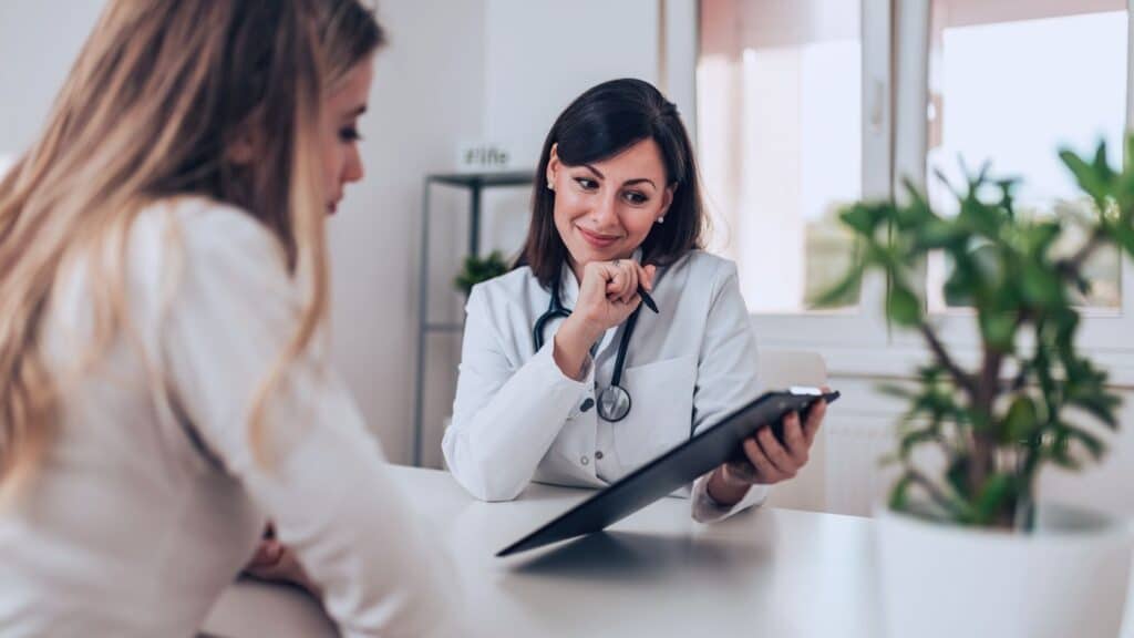 Equiparação Hospitalar: quem tem direito e as mudanças recentes. Imagem com médica e paciente em consultório representando direitos trabalhistas