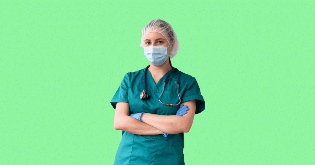 Médica com máscara, touca e uniforme hospitalar cruzando os braços, representando avanços científicos em saúde e pesquisas sobre a proteína polilaminina para recuperação de movimentos após lesão medular.