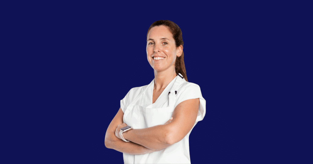 Fisioterapeuta sorridente de jaleco branco com braços cruzados, representando credibilidade e profissionalismo em contabilidade para fisioterapeutas.