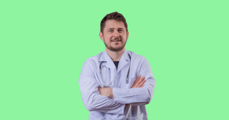 Médico sorridente vestindo jaleco branco e estetoscópio cruza os braços enquanto olha para a câmera. Fundo verde claro sólido. Imagem ilustrativa para conteúdo sobre áreas da medicina mais bem pagas.