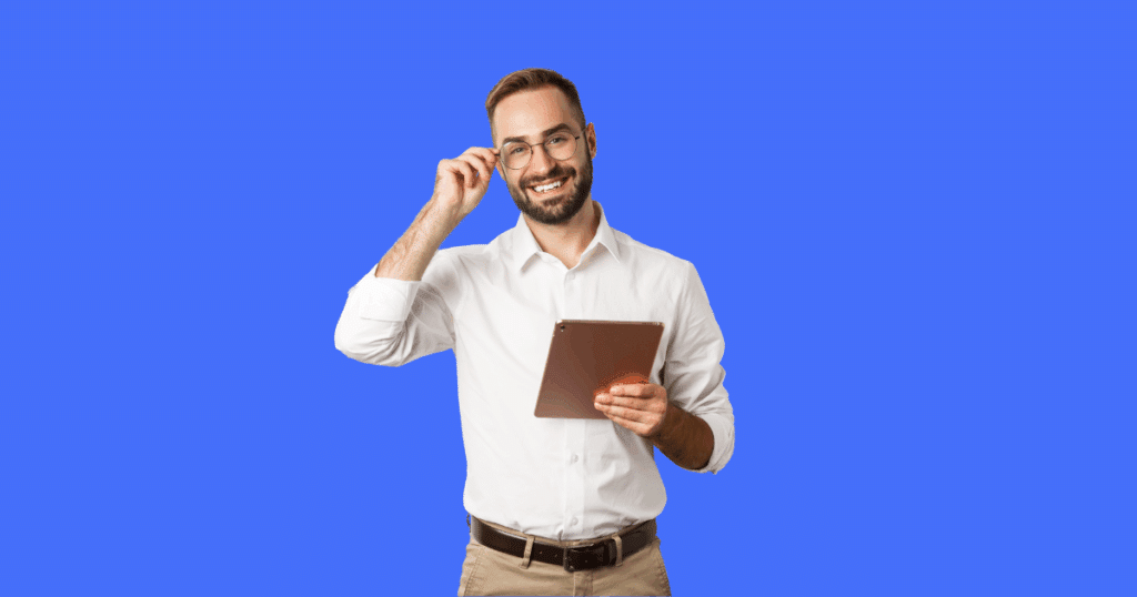 Homem sorridente usando óculos e camisa branca segura um tablet em uma das mãos, enquanto ajusta os óculos com a outra. Fundo azul sólido. Imagem ilustrativa para conteúdo sobre Fator R do Simples Nacional