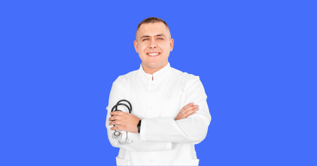 Médico sorridente vestindo jaleco branco cruza os braços enquanto segura um estetoscópio. Fundo azul sólido. Imagem ilustrativa para conteúdo sobre como um médico pode pagar menos impostos.