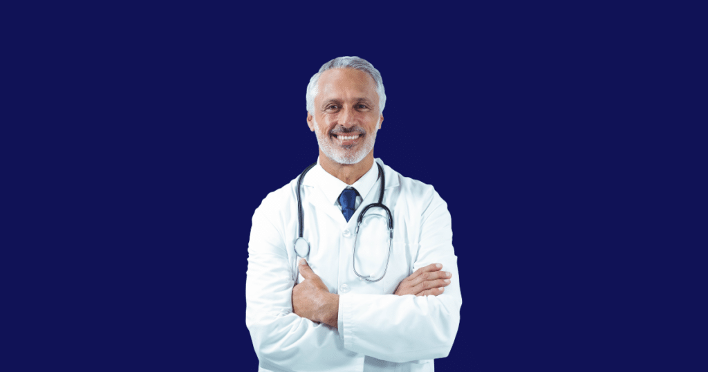 Médico sorridente de cabelos grisalhos vestindo jaleco branco, gravata e estetoscópio cruza os braços enquanto olha para a câmera. Fundo azul escuro sólido. Imagem ilustrativa para conteúdo sobre restituição do Imposto de Renda.