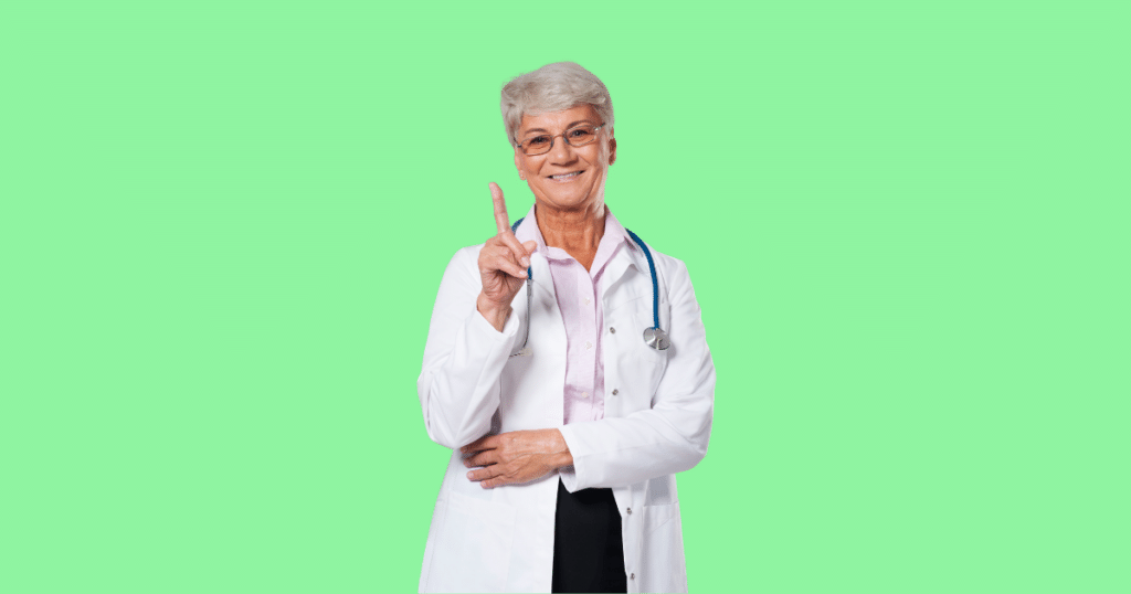 Médica de cabelos grisalhos e óculos, vestindo jaleco branco, com estetoscópio no pescoço, aponta com um dedo para cima enquanto sorri. Fundo verde claro sólido. Imagem ilustrativa para conteúdo sobre retificação do Imposto de Renda.