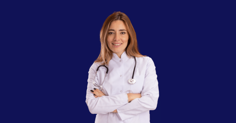Médica sorridente vestindo jaleco branco e estetoscópio cruza os braços enquanto olha para a câmera. Fundo azul escuro sólido. Imagem ilustrativa para conteúdo sobre tipos de tributos no Brasil.